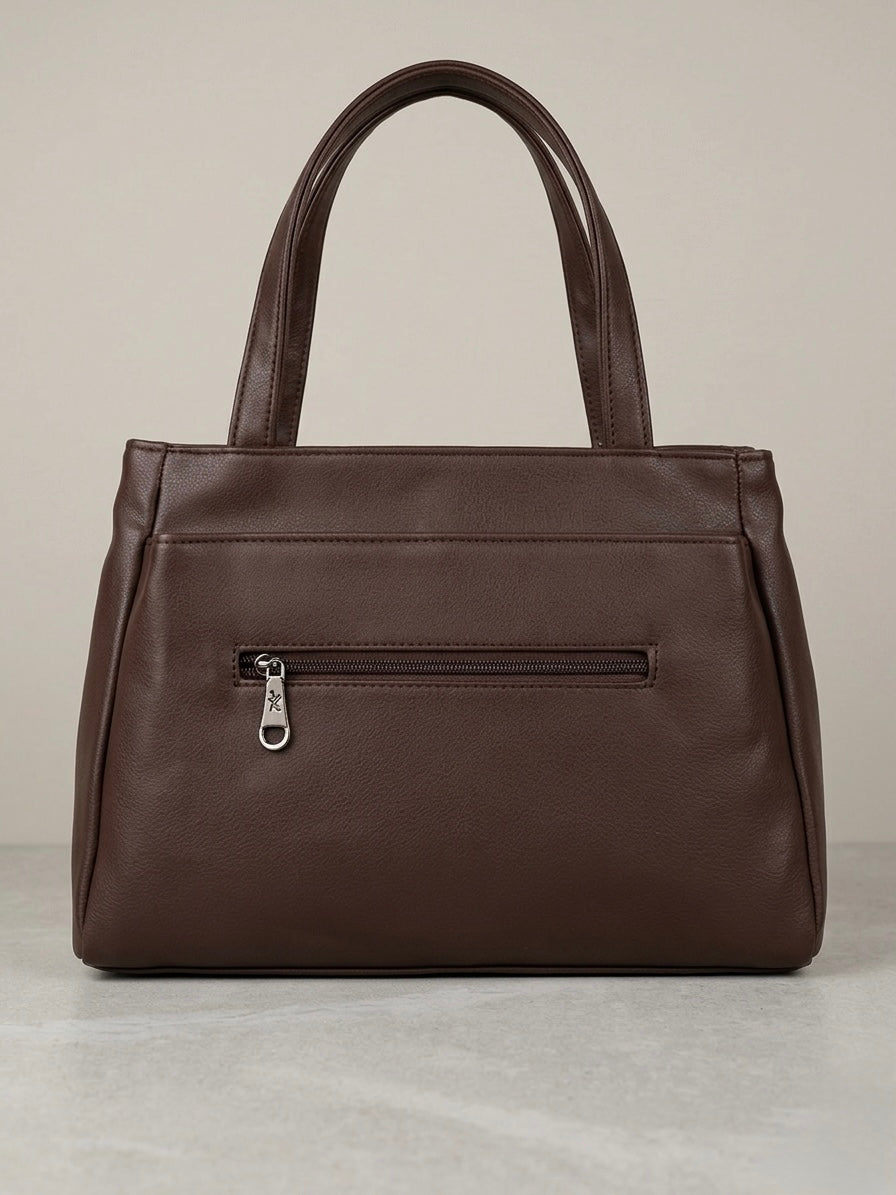 Brown leather handbag with a visible zipper on a light gray background