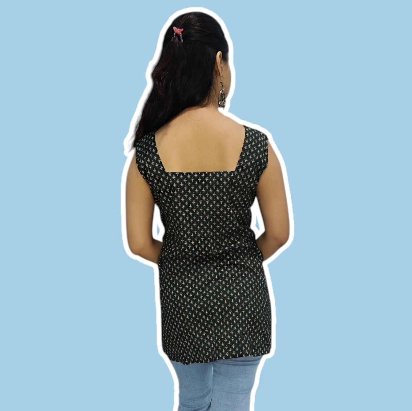 Woman wearing a black patterned top on a light blue background